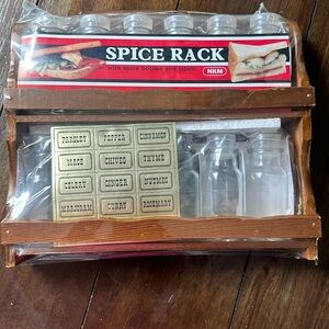 Vintage spice rack with spice bottles and labels.